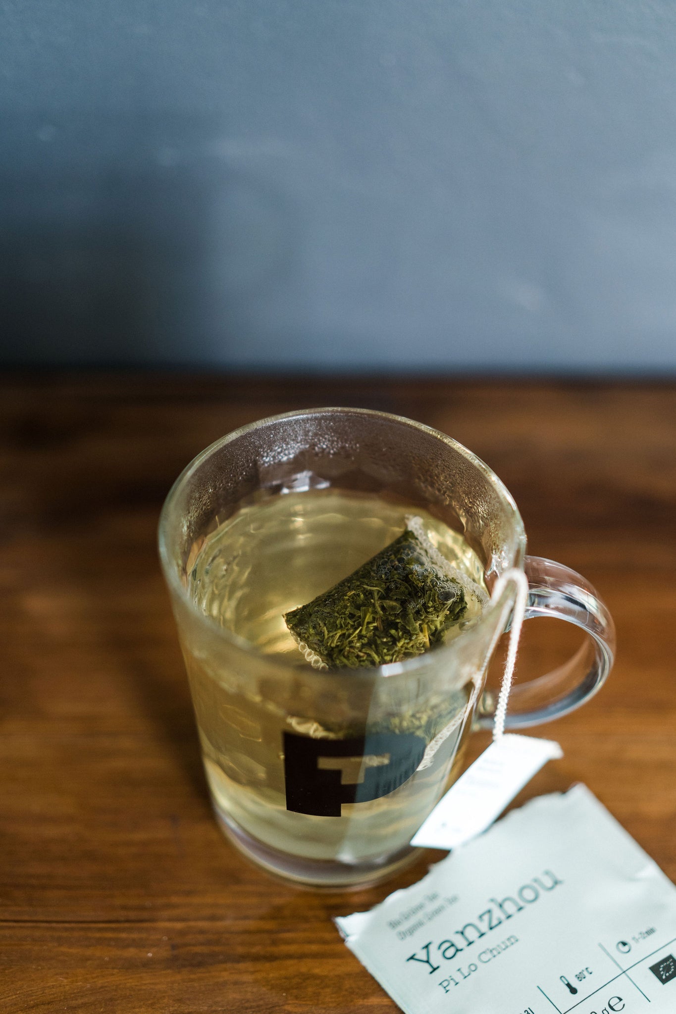 glasskopp med grønn te og tepose sett ovenfra 